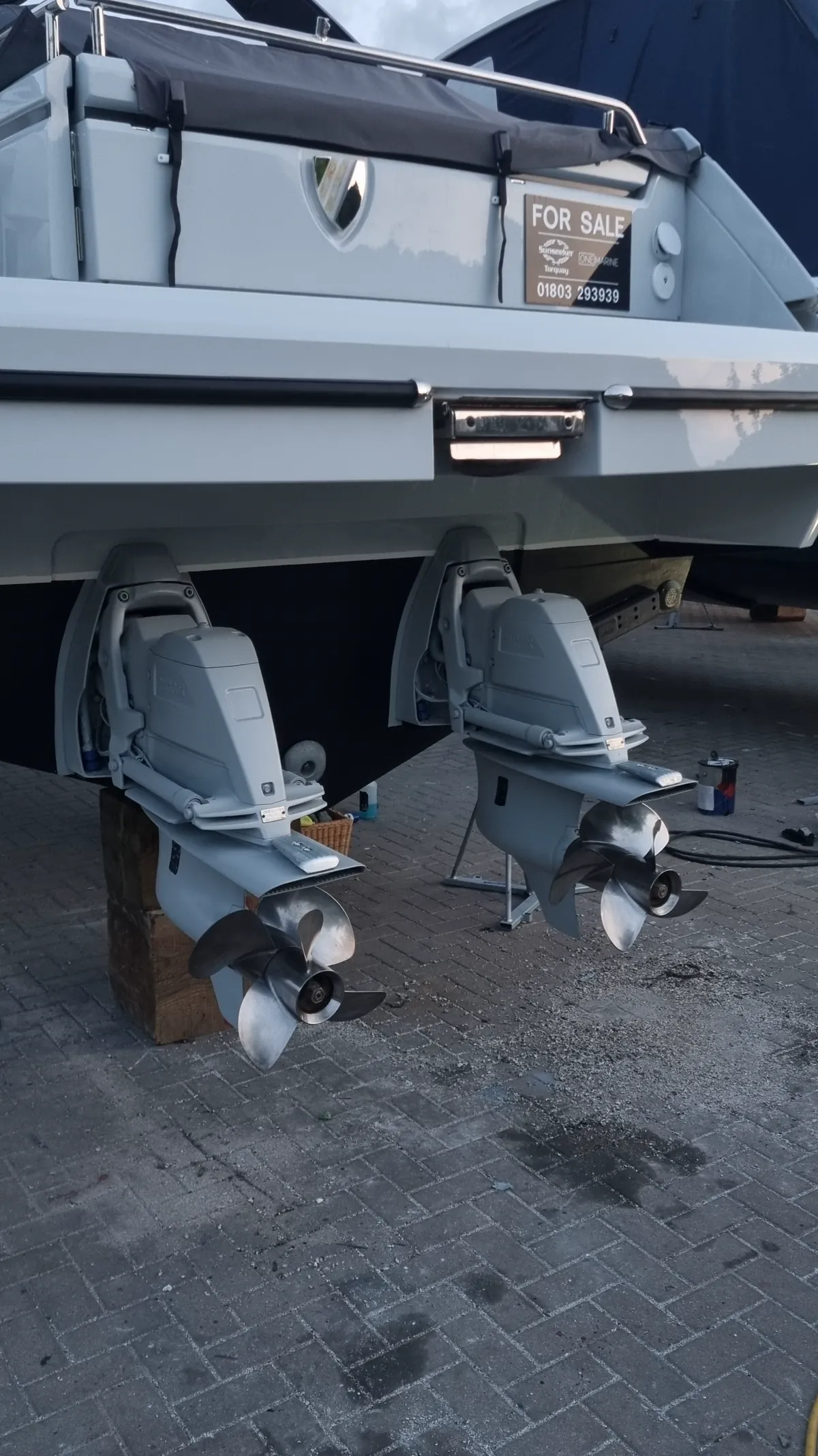 Motor yacht lifted on stands, hull and sterndrives ready for antifouling